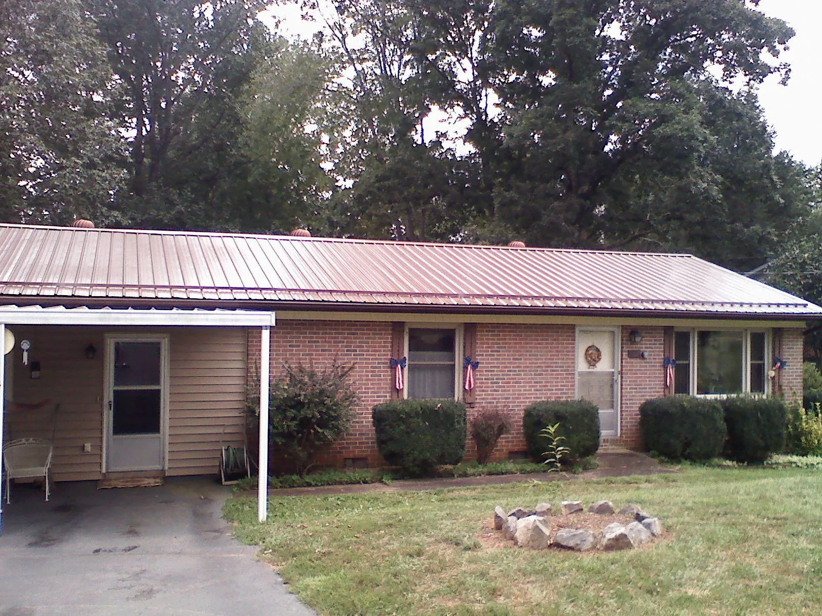 Bronze metal roof and carport on a brick ranch home — Roof Repair work by our crew in Norwich